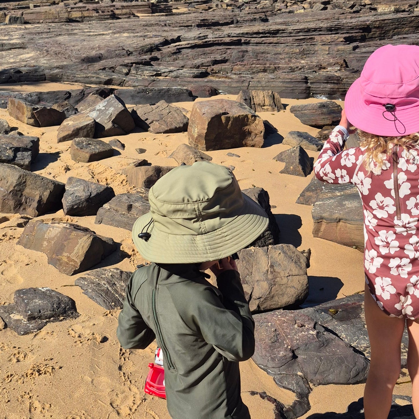 kids walking on the sand wearing surf hats with wide brim