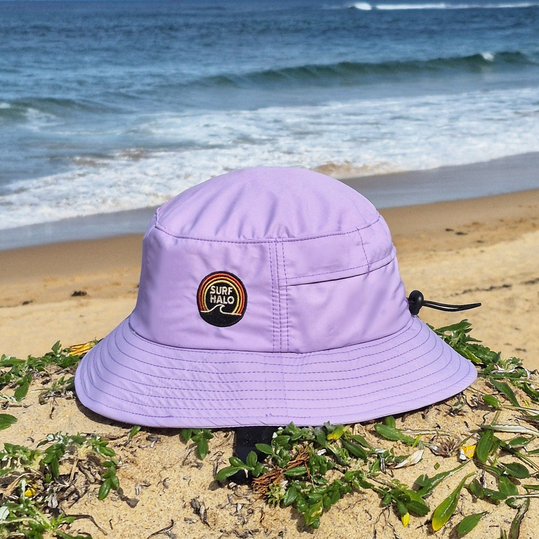 lilac pink surf hat bucket style with UPF 50+ and wide brim on a beach helmet insert protective shell