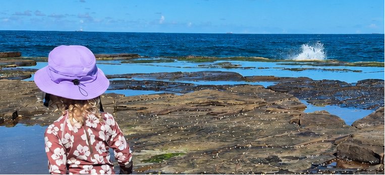 child wearing surf hat helmet in the reef 